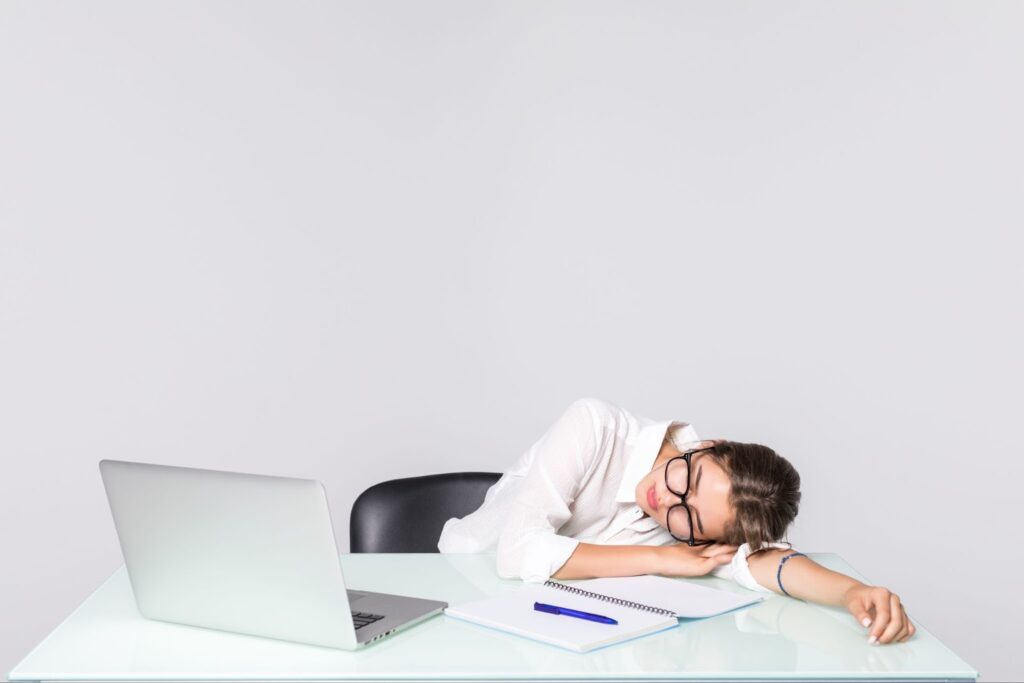 Woman asleep at her desk near laptop