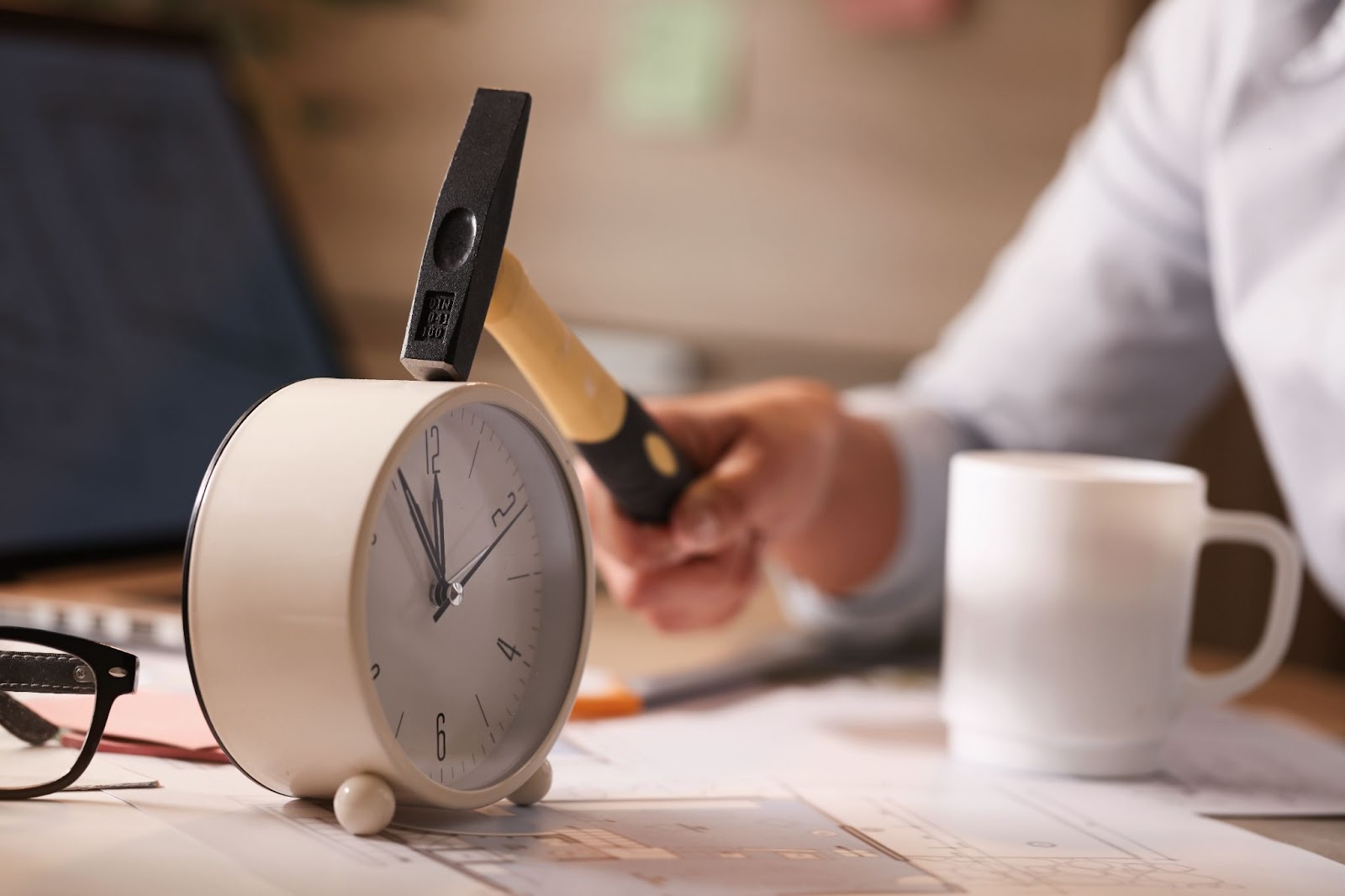 Woman hitting clock on her desk while working in the office