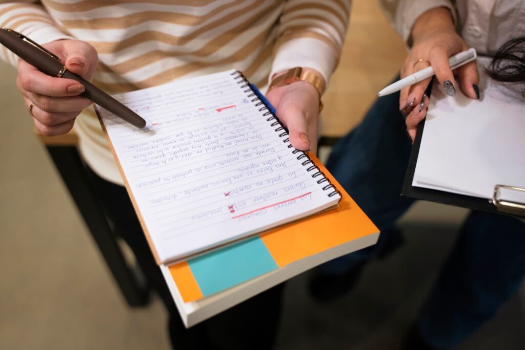 The girl is holding a notepad in her hands and checking something