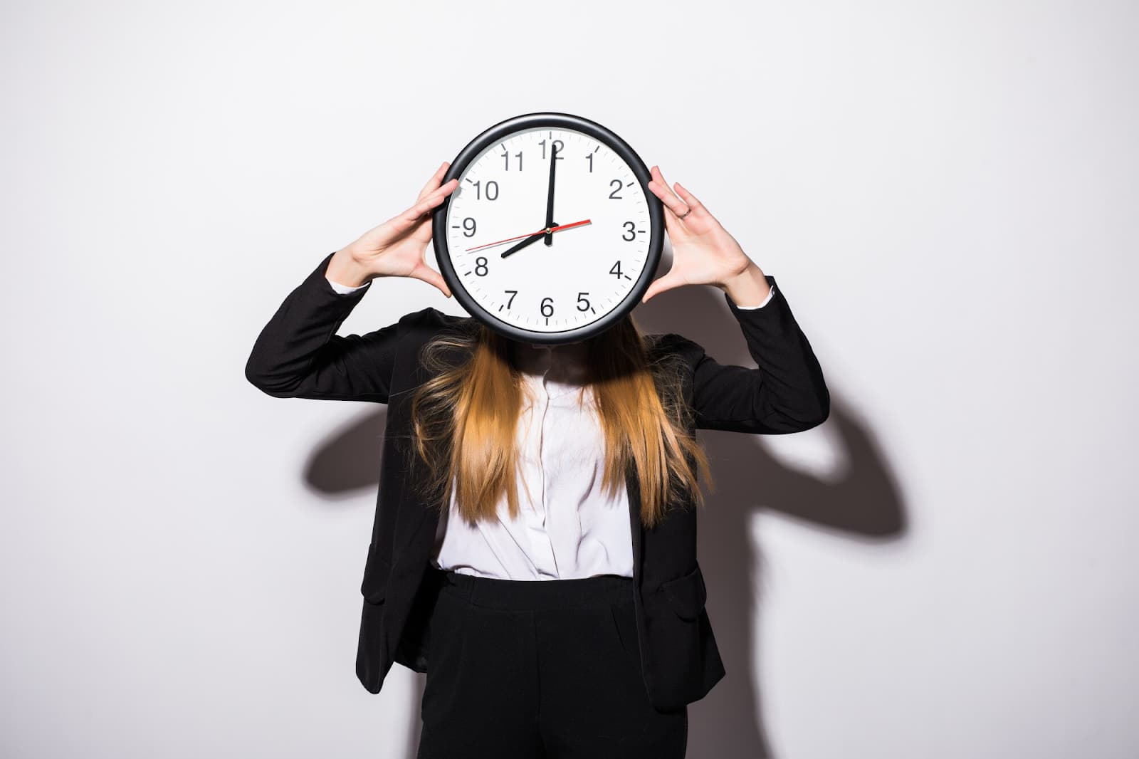 A girl holds a watch at head level