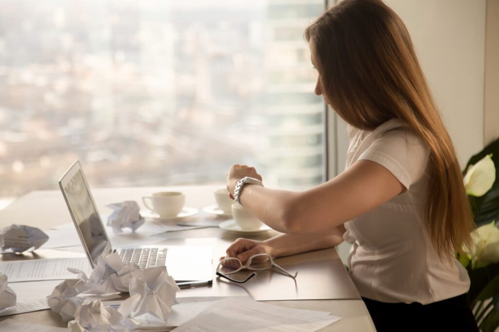 Business woman looking at her wristwatch and checking the time