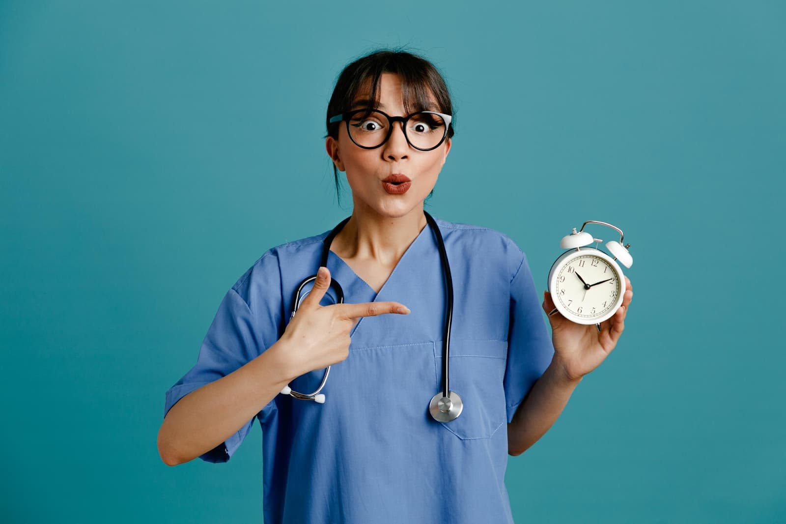 Female doctor in uniform with alarm clock