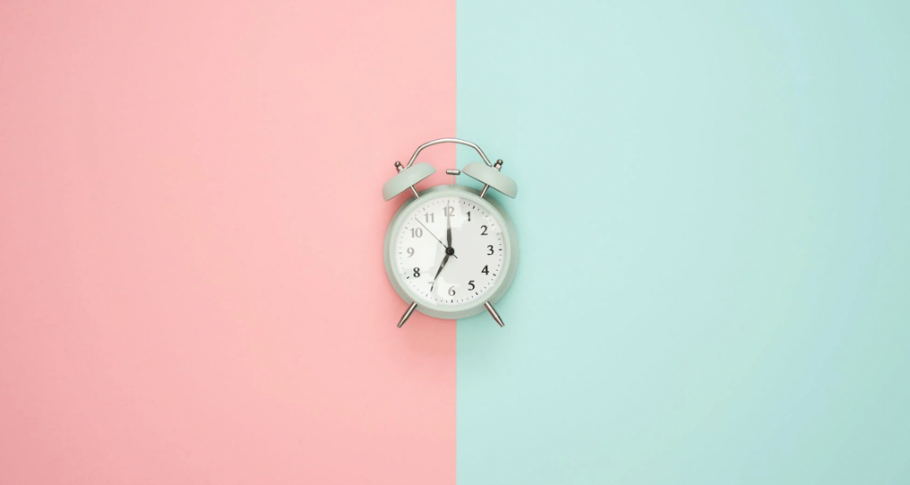 Alarm clock on a pink and blue background