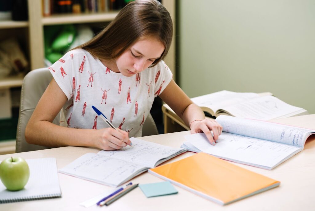 Student sitting and writing her homework